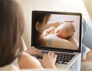 Mother and newborn baby on laptop screen, illustrating breastfeeding support and maternal care.