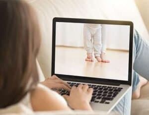 Healthy baby standing on a laptop screen during a virtual consultation.